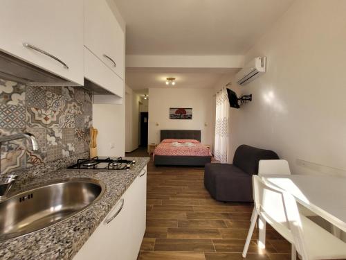 Il comprend une cuisine avec un évier et un salon avec un lit. dans l'établissement Casa "Paolo e Francesca" Monolocali, à Scilla