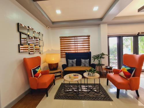 a living room with orange chairs and a couch at Bayview Country Inn El Nido in El Nido