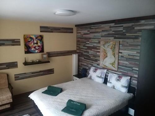 1 dormitorio con 1 cama con 2 almohadas verdes en Къща за гости "Там край реката " en Slivek