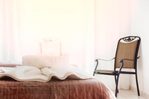 a bed with a blanket and a chair in a room at Galini apartments Polyhrono in Kassandria