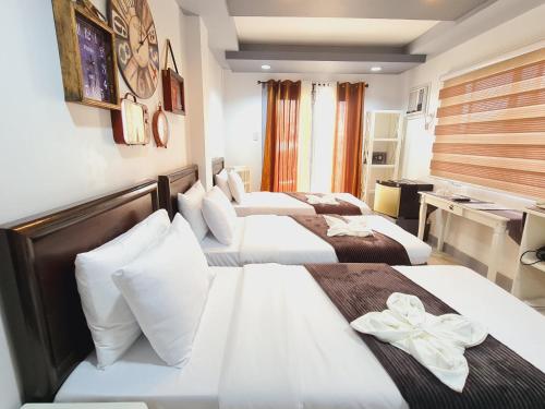 a hotel room with two beds and a desk at Bayview Country Inn El Nido in El Nido