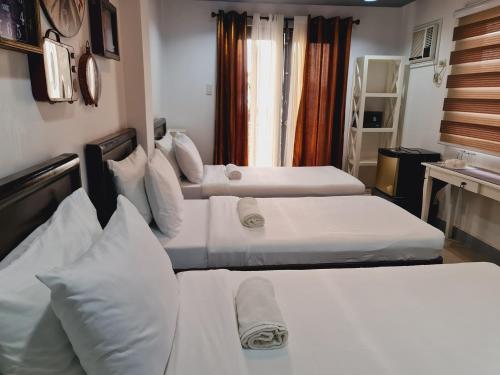 a hotel room with three beds in it at Bayview Country Inn El Nido in El Nido