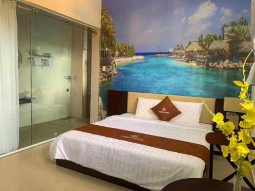 1 dormitorio con 1 cama y una pintura de playa en THÀNH VINH Hotel en Ấp Trảng