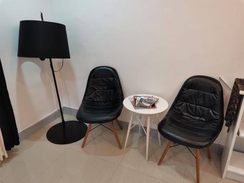 two black chairs and a small table with a lamp at Bayview Country Inn El Nido in El Nido