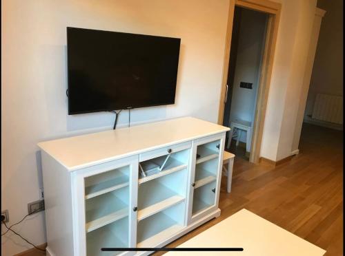 un centro de entretenimiento blanco con TV de pantalla plana en la pared en Apartamento con encanto en Igualada