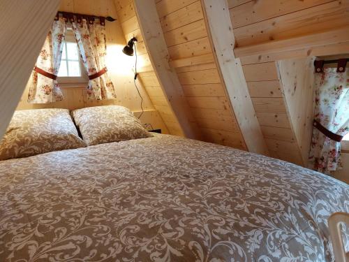 a bedroom with a bed in a room with wooden walls at des Vignes et des Songes in Saint-André-et-Appelles