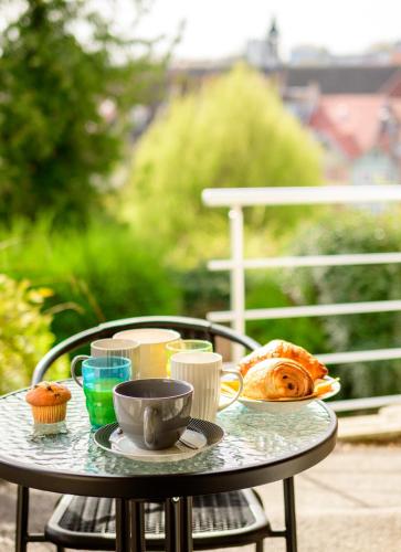a table with food and cupcakes on it at Le 31-GregIMMO-Appart'Hôtel in Montbéliard