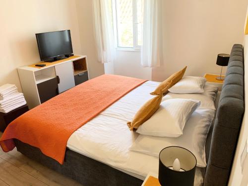 a bedroom with a large bed and a tv at Apartments Casa Toni Dubrovnik in Dubrovnik