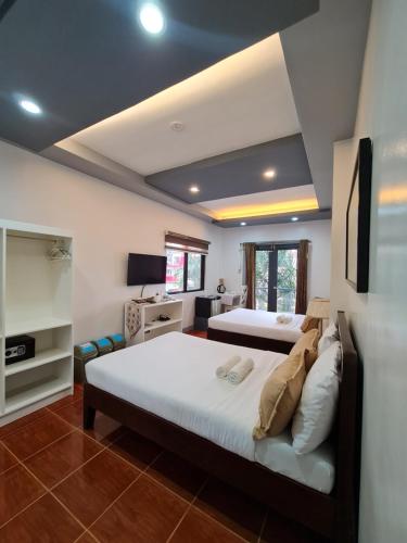 a bedroom with two beds and a television in it at Bayview Country Inn El Nido in El Nido