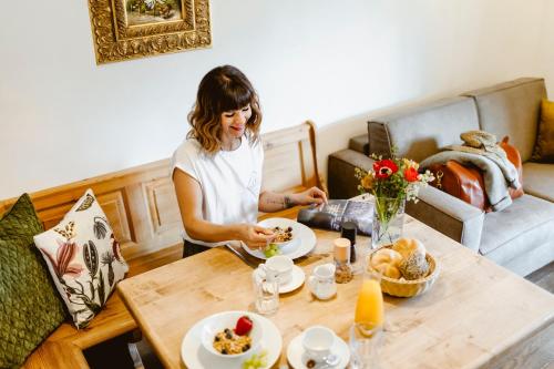 a woman sitting at a table eating food at Seehotel Berau in St. Wolfgang