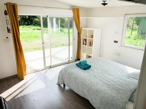 une chambre avec un lit avec une serviette bleue dessus dans l'établissement Ker Gaouenn - moderne & cosy (pergola, jardin, terrasse géante...) - bonne connexion - intime (guide personnalisé en cadeau), à Les Fougerêts