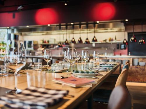 a table in a restaurant with wine glasses on it at Urban Nature St Peter-Ording in Sankt Peter-Ording