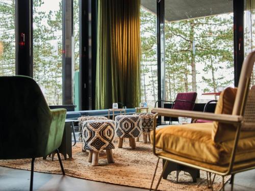 a room with chairs and tables and windows at Urban Nature St Peter-Ording in Sankt Peter-Ording