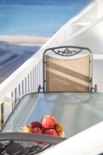 a bowl of fruit on a glass table on a balcony at Galini apartments Polyhrono in Kassandria