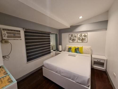 a bedroom with a white bed and a window at Bayview Country Inn El Nido in El Nido