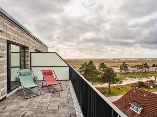 two chairs sitting on a balcony with a view at Urban Nature St Peter-Ording in Sankt Peter-Ording