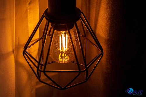 a light hanging from a wall with a cage style light fixture at MODERN apartments WAVE near the AIRPORT in Velika Gorica