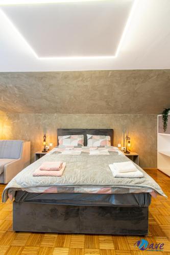 a bedroom with a large bed with a stone wall at MODERN apartments WAVE near the AIRPORT in Velika Gorica