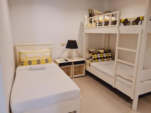 a bedroom with two beds and a bunk bed at Bayview Country Inn El Nido in El Nido