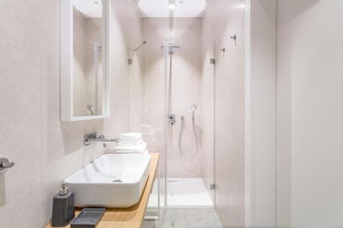 a white bathroom with a sink and a shower at Gdynia Baltiq Plaza in Gdynia