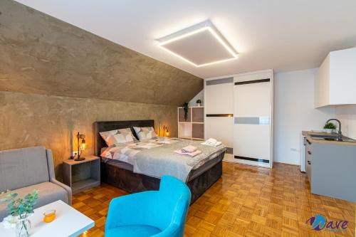 a bedroom with a bed and a blue chair at MODERN apartments WAVE near the AIRPORT in Velika Gorica