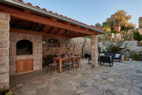 a stone patio with a wooden pergola at Apartments Micika in Cavtat