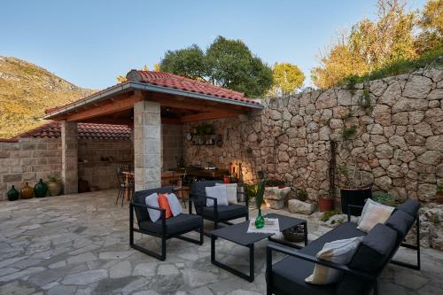 un patio con sedie e un muro in pietra di Apartments Micika a Cavtat