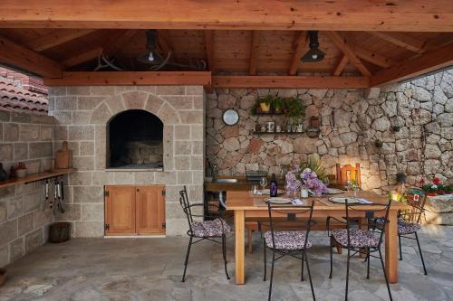 a dining room with a table and a stone wall at Apartments Micika in Cavtat