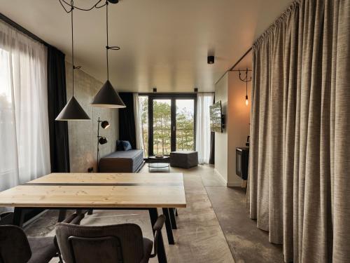 a living room with a wooden table and chairs at Urban Nature St Peter-Ording in Sankt Peter-Ording