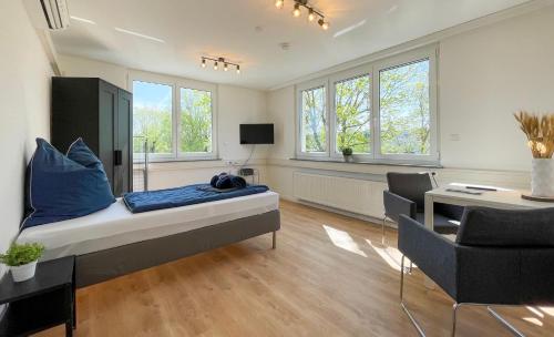 a bedroom with a bed and a desk and chairs at Hegau Boardinghouse in Singen