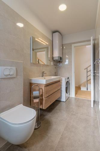 a bathroom with a white toilet and a sink at Best Sea View Apartment in Cres