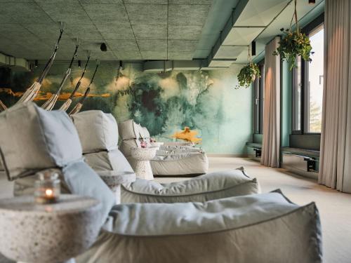 a room with couches and a painting on the wall at Urban Nature St Peter-Ording in Sankt Peter-Ording