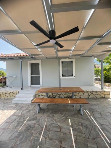 a table on a patio with a ceiling fan at Aloni house in Leonidion