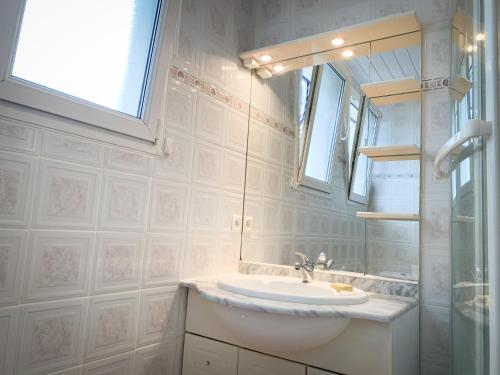 une salle de bain avec un lavabo et un miroir dans l'établissement Ker Gaouenn - moderne & cosy (pergola, jardin, terrasse géante...) - bonne connexion - intime (guide personnalisé en cadeau), à Les Fougerêts