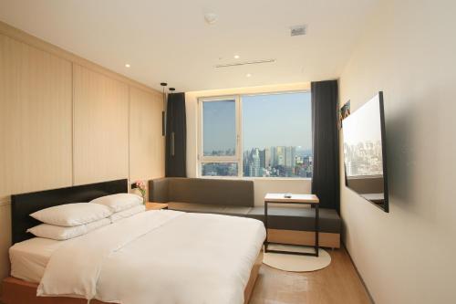 a bedroom with a bed and a large window at Hotel The Designers Hongdae in Seoul