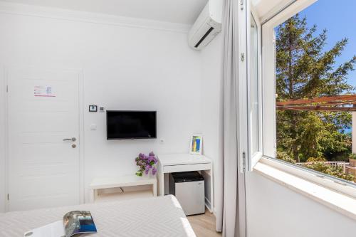 a white room with a window and a tv at Rooms D&L, FREE Parking on-site in Dubrovnik