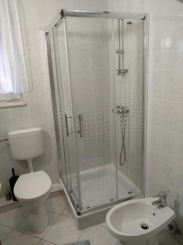 a bathroom with a shower and a toilet and a sink at Manor Villa in Hévíz