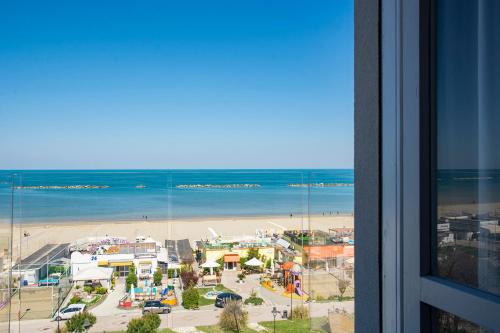 a view of a beach and the ocean from a building at Hotel Atlas in Cesenatico