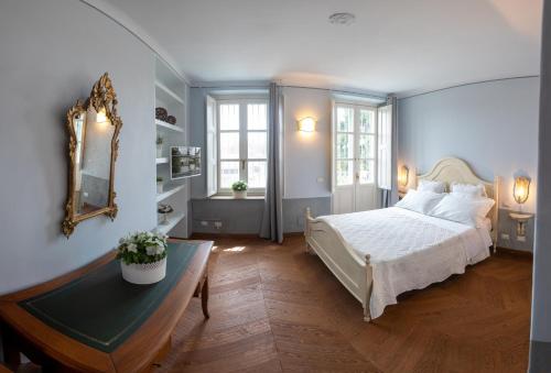 um quarto com uma cama, uma mesa e um espelho em B&B Villa Ricardi em Moncalieri
