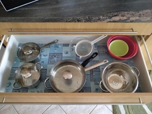 a drawer filled with pots and pans on a table at Manor Villa in Hévíz