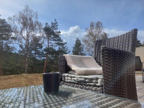 a wicker chair sitting on a table on a patio at Apartman SRNA, Vila JEZERO in Divčibare