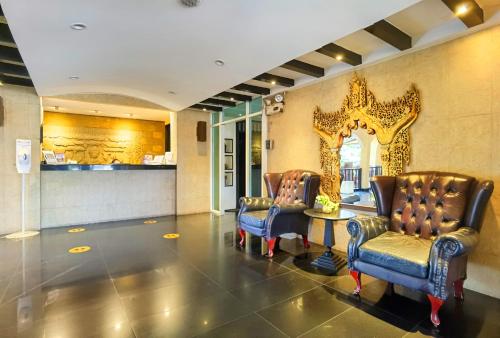 a lobby with two chairs and a table and a mirror at Nova Park Hotel by Compass Hospitality in Pattaya Central