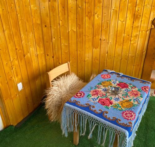 a table and a chair with a blanket on it at Casa Grai Moroșănesc in Breb