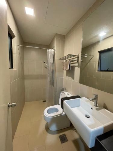 een badkamer met een wit toilet en een wastafel bij Swiss Garden Resort Residence (Beach & Waterpark) in Kuantan