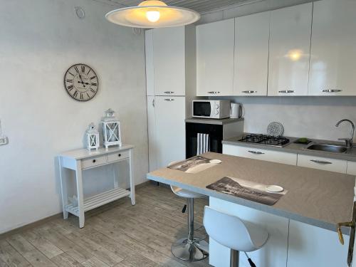 a kitchen with a counter and a clock on the wall at Appartamento bianco in Menaggio
