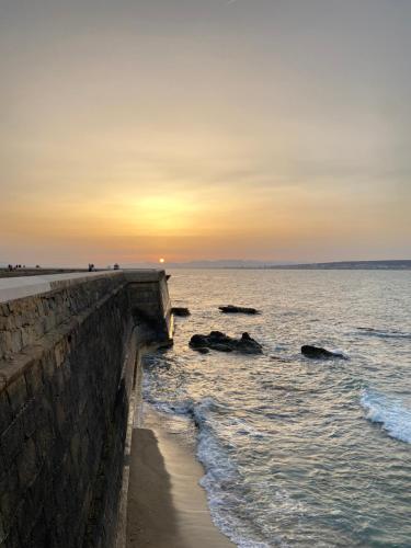 un coucher de soleil sur l'océan avec des rochers dans l'eau dans l'établissement Iaia Carmen, à Tabarca