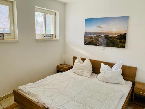 a bedroom with a bed with white sheets and pillows at 100 Sekunden zum Strand: Schöne Wohnung auf Usedom in Karlshagen