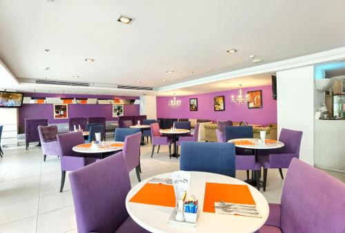 パタヤ・セントラルにあるNova Suites Pattaya by Compass Hospitalityのダイニングルーム(テーブル、紫色の椅子付)