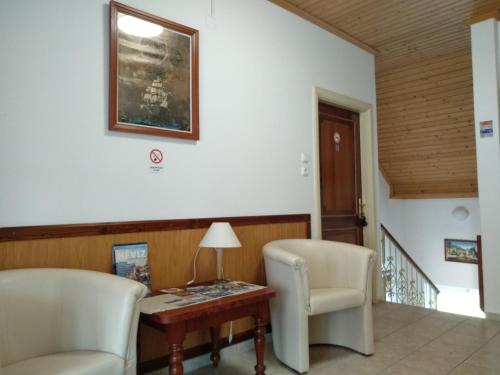a living room with two chairs and a table at Manor Villa in Hévíz