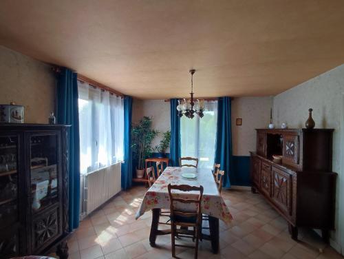 ein Esszimmer mit Tisch und Stühlen und Fenstern in der Unterkunft Maison de vacances en Dordogne in Lanquais